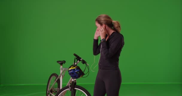 Femme caucasienne en tenue de sport allant faire du vélo sur écran vert. Sur écran vert à saisir ou à composer. - Séquence, vidéo