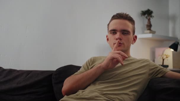 Teenager-Mann blickt in Kamera und zeigt Schweigezeichen Geheime Emotion. Hochwertiges 4k Filmmaterial - Filmmaterial, Video