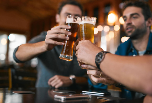 Menestyksekkääseen liiketoimintaan tulevaisuudessa. kolme iloista nuorta miestä juhlimassa oluen kanssa istuessaan pöydässä oluen panimon sisällä päivän aikana - Valokuva, kuva