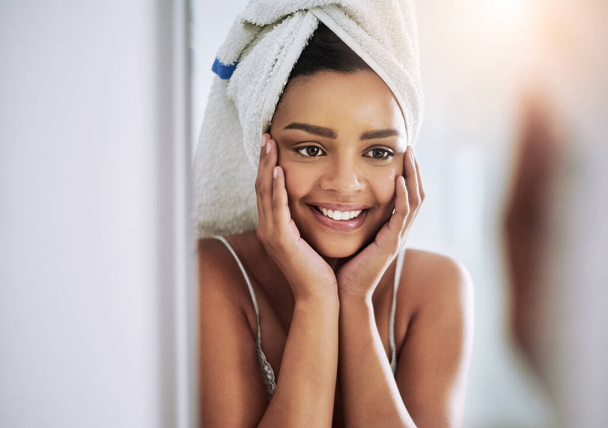 Привет, красавица. привлекательная молодая женщина, смотрящая на свое лицо в зеркало ванной - Фото, изображение