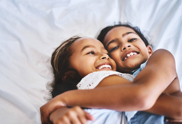 Her zaman birbirimize sahip olacağız. Gün boyunca evde bir yatakta yatarken kollarını birbirine dolamış iki küçük kızın portresi. - Fotoğraf, Görsel