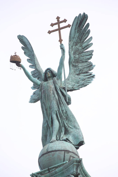 Статуя на площади Героев Будапешта. На вершине колонны изображен архангел Гавриил, держащий венгерскую корону и апостольский двойной крест в руках. - Фото, изображение