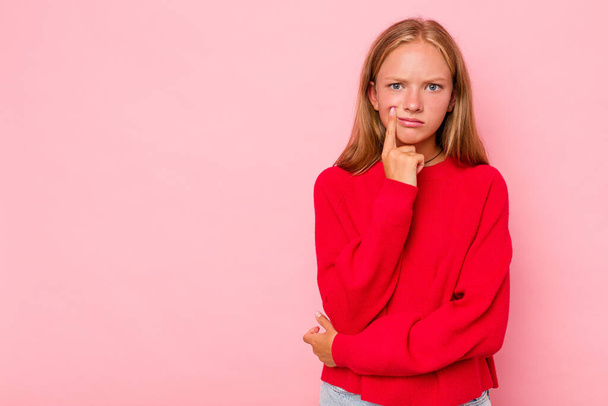 Caucasian teen girl isolated on pink background looking sideways with doubtful and skeptical expression. - Foto, afbeelding