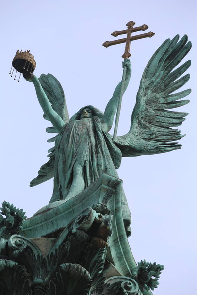Статуя на площади Героев Будапешта. На вершине колонны изображен архангел Гавриил, держащий венгерскую корону и апостольский двойной крест в руках. - Фото, изображение