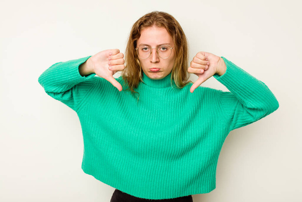 Young caucasian woman isolated on white background showing a dislike gesture, thumbs down. Disagreement concept. - Foto, immagini