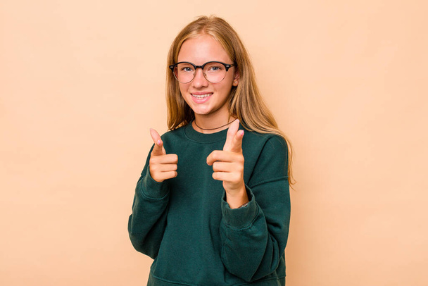 Caucasian teen girl isolated on beige background pointing to front with fingers. - Foto, Imagem