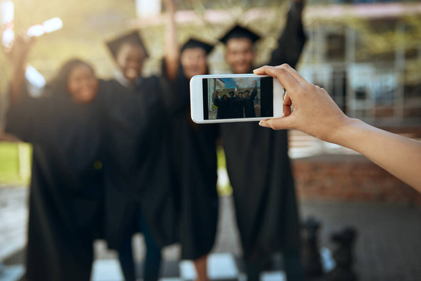 Snapshots van de diploma-uitreiking. een groep studenten die foto 's maken met een mobiele telefoon op de afstudeerdag - Foto, afbeelding