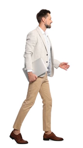 Man with laptop walking on white background - Foto, Imagen