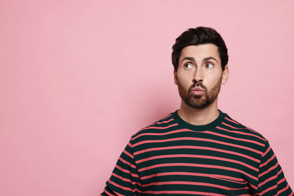 Handsome man blowing kiss on pink background. Space for text - Foto, afbeelding
