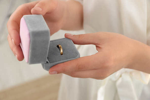Bride holding box with engagement ring indoors, closeup. Wedding day - Foto, Imagen