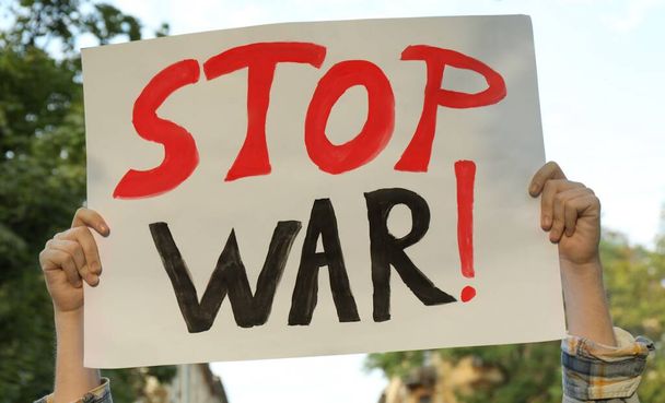 Woman holding poster with words Stop War outdoors, closeup - Фото, изображение