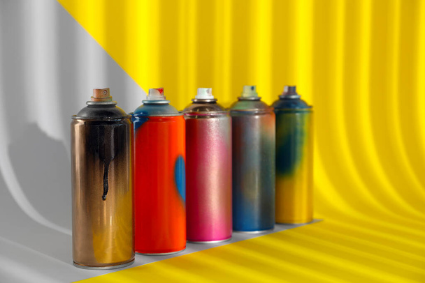 Used cans of spray paints on color background - Fotografie, Obrázek