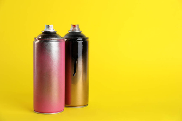 Used cans of spray paints on yellow background. Space for text - Zdjęcie, obraz