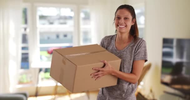 Vrolijke jonge vrouw met pakket van internet aankoop opgewonden om het te openen. Mooi blank meisje die kartonnen doos in de lucht gooit. 4k - Video