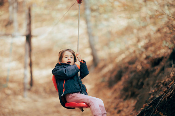 Little Girl Going Ziplining Enjoying it in Adventure Park - 写真・画像
