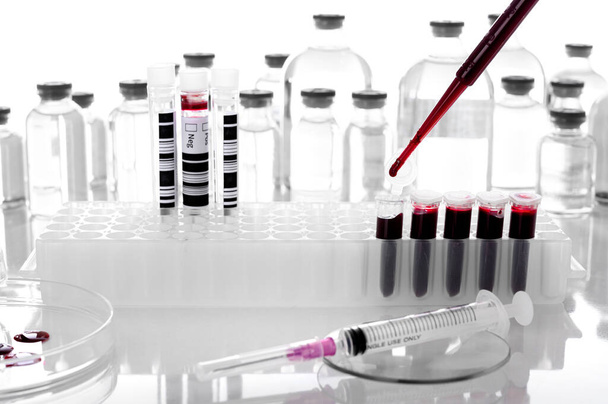 Pipeta soltar amostra de sangue em tubo de PCR ou líquido vermelho em placa de PCR no fundo do laboratório- bioquímica molecular biologia- genética e conceitos de química clínica - Foto, Imagem