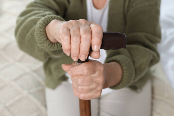 Elderly woman with walking cane indoors, closeup. Home care service - Fotoğraf, Görsel