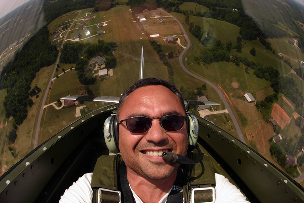 Частный пилот наслаждается поездкой на винтажном P-51 Mustang в ясный день. - Фото, изображение