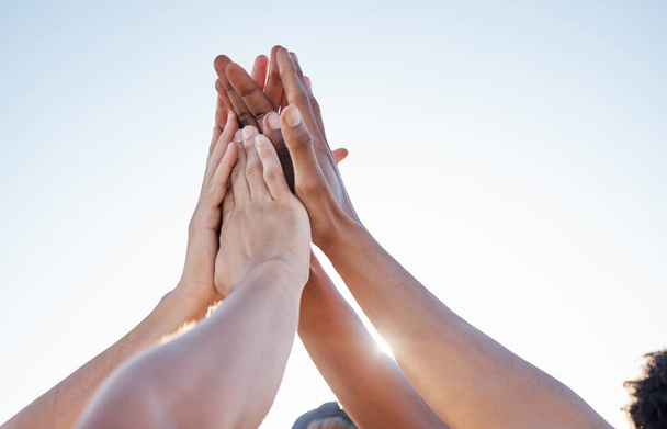 Hands, high five and collaboration on sports goal with friends in trust huddle for motivation, support and energy. Hand, fitness and people in team for exercise, workout and training against blue sky. - Foto, Imagem