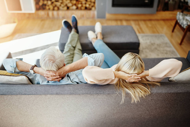 Welcome to retirement. High angle shot of an unrecognizable mature couple relaxing on the sofa at home - Fotoğraf, Görsel