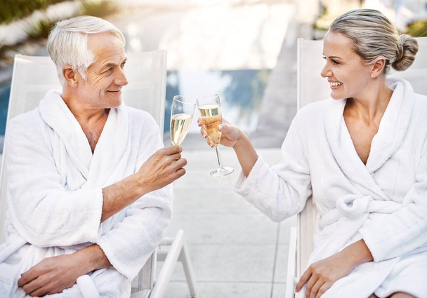 Žijeme si v tento krásný den. veselý pár středního věku s oslavným přípitkem se šampaňským venku během dne - Fotografie, Obrázek