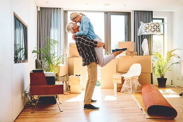 Наполняют каждую комнату своего нового дома любовью. счастливая зрелая пара, обнимающаяся в день переезда - Фото, изображение