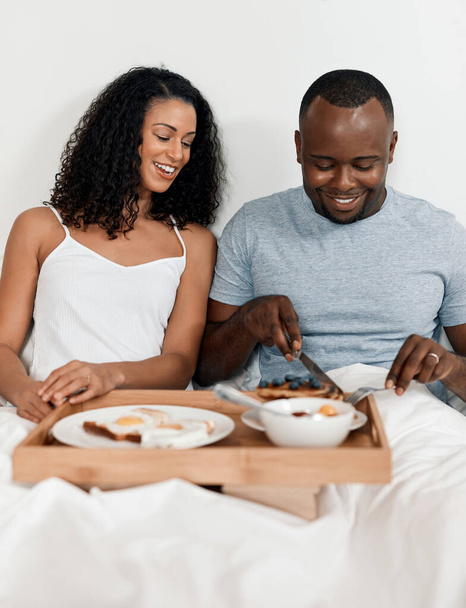 Che bel modo di iniziare la nostra giornata. una giovane coppia allegra che si gode la colazione a letto insieme a casa durante il giorno - Foto, immagini