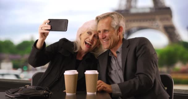 Mature couple taking a selfie in Paris. Portrait of smiling male and female taking picture with the Eiffel Tower in background. 4k - Footage, Video