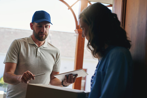 Sacando sus entregas. un mensajero haciendo una entrega a un cliente en su casa - Foto, Imagen