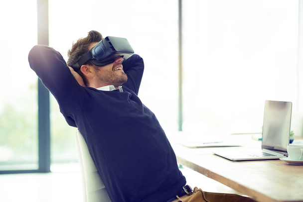 Biznes i relaks w jednym. biznesmen noszący słuchawki VR, opierający się z powrotem na krześle biurowym w pracy - Zdjęcie, obraz
