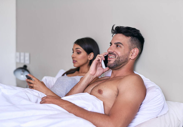 Conectando como um casal. um jovem casal usando um celular em sua cama em casa - Foto, Imagem