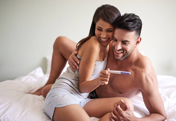 Kaikki, mitä olemme halunneet. nuori aviopari hurmioitunut tuloksista raskaustestin heidän makuuhuoneessa kotona - Valokuva, kuva