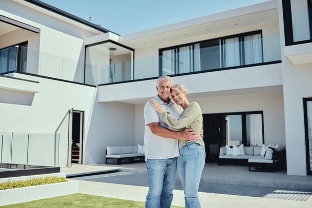 Real estate, couple and happiness of people with a new house property purchase outdoor. Portrait of happy, smile and marriage of a senior man and woman together in retirement smiling with a hug. - Photo, Image