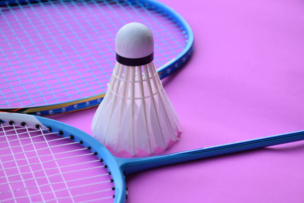 Cremeweißer Federball und Schläger auf dem Boden im Badmintonhallenplatz, Kopierraum, weicher und selektiver Fokus auf Federbälle. - Foto, Bild