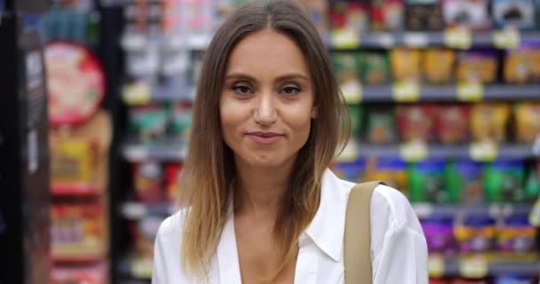 Lähikuva muotokuva itsevarma nainen kuluttaja hymyilee iloinen hammas hymy katselee kameraa aikana ruokaostokset - Materiaali, video