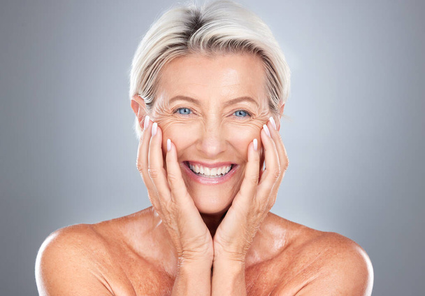 Portrait, senior woman and beauty, skincare and wellness in studio for grooming, hygiene and pamper routine on grey background. Face, elderly model and happy, smile and excited about facial treatment. - Foto, Imagen