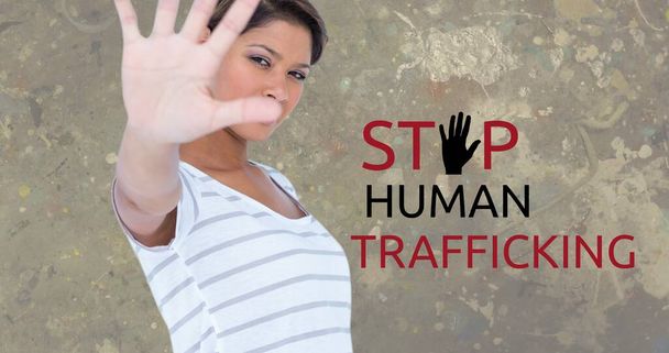 Composite of stop human trafficking text over biracial woman showing stop sign against gray wall. Gesture, copy space, crime, freedom, awareness and prevention concept. - Foto, immagini