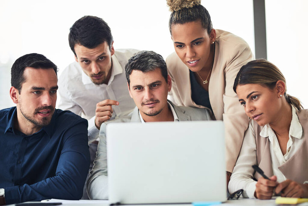 Trabalhando de perto como uma equipe comprometida. um grupo de empresários trabalhando juntos em um laptop em um escritório - Foto, Imagem