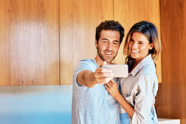 We take the best selfies together. a happy young couple taking a selfie together at home - Fotó, kép