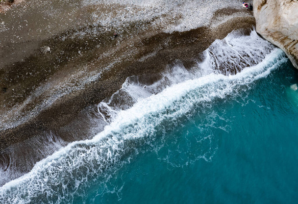 Avión teledirigido de costa rocosa con olas marinas golpeando la orilla. Paisaje marino desde arriba. Roca de Afrodita Paphos jalá Roca de Afrodita Paphos Chipre - Foto, Imagen