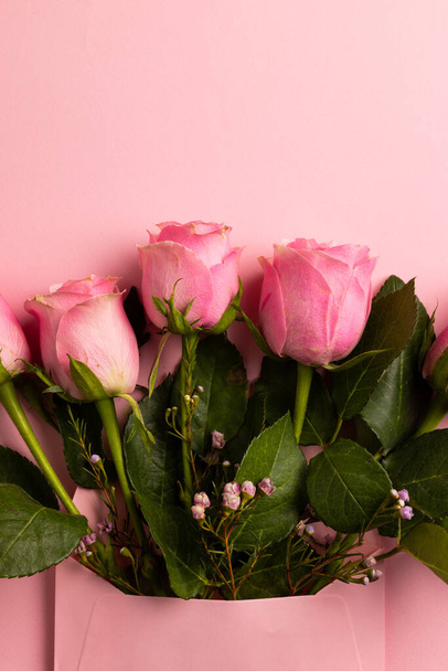 Composition of roses on pink background. Valentines day, celebration and copy space, digital composite image. - Zdjęcie, obraz