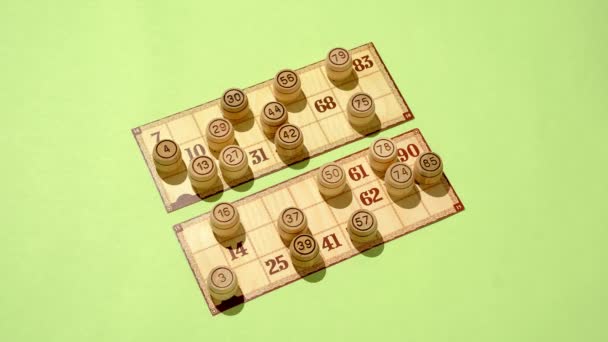 Masa oyunu loto fıçıları ve yeşil arka planda numaraları olan kartlar. Aile eğlencesi ve eğlencesi konsepti. - Video, Çekim
