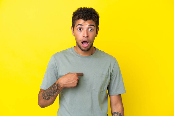 Nuori komea brasilialainen mies eristetty keltaisella taustalla osoittaa itseään - Valokuva, kuva