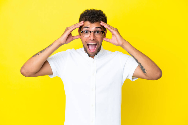 Young handsome Brazilian man isolated on yellow background with surprise expression - Foto, immagini