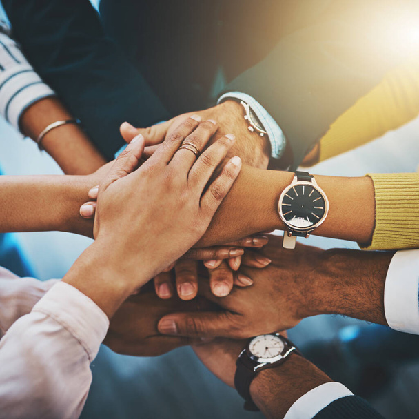 Only great things can be accomplished with teamwork. Closeup shot of an unrecognizable group of businesspeople joining their hands together in a huddle - Photo, Image