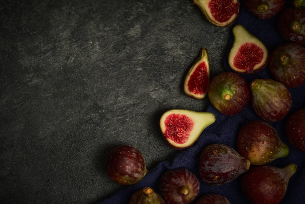 вид зверху цілий і нарізані фрукти інжиру на чорному фоні
 - Фото, зображення