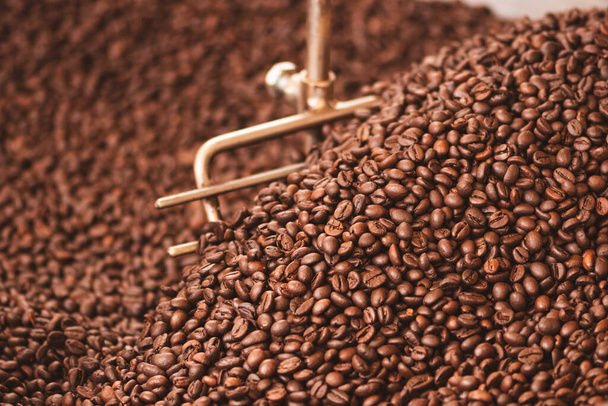 Roasting coffee beans in a professional old coffee roasting machine or roaster, close up - Foto, imagen