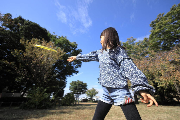 Japanese student girl playing flying disc (8 years old) - Φωτογραφία, εικόνα