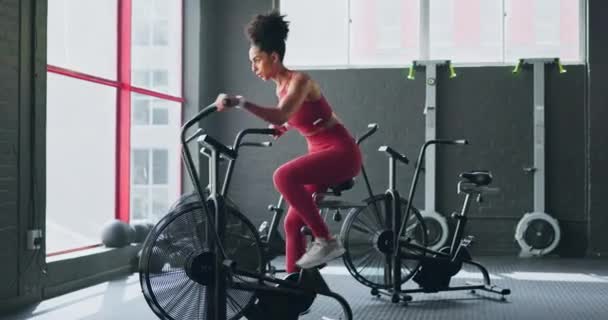 Exercise bike, cardio and girl cycling for sports fitness, athlete marathon training or high energy body workout. Gym performance motivation, wellness mindset and black woman riding bicycle machine. - Footage, Video