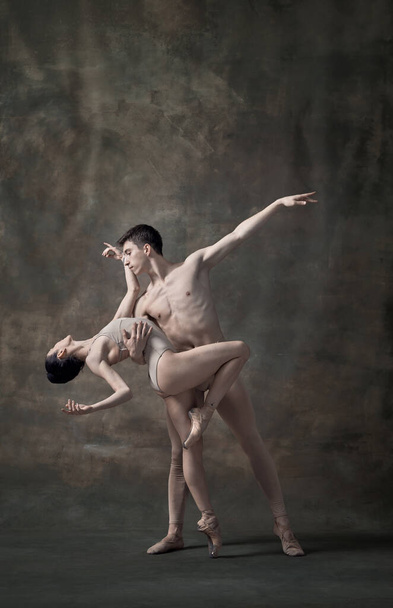 Молодий чоловік і жінка, танцюристи балету виконують ізольовані на темно-зеленому вінтажному тлі. Прихильність. Сучасний балет. Концепція класичного танцю, художника, краси. Копіювати простір для оголошення
 - Фото, зображення